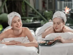 due donne in asciugamano e turbante mangiano da un piattino alle terme