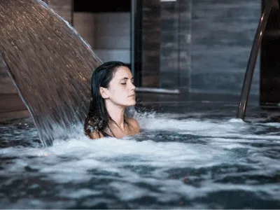 una donna in un bagno termale con cascata