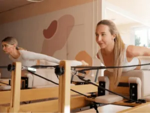 una donna fa esercizi di Pilates con un apposito macchinario